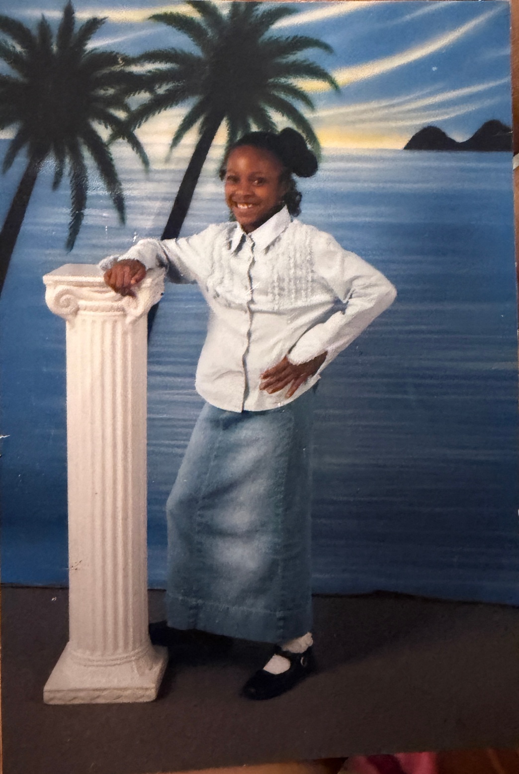 A young person smiling confidently against a tropical beach backdrop, celebrating the first step